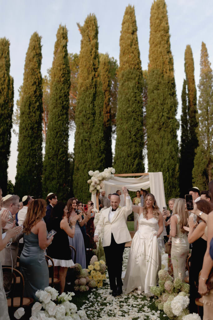 A Three-Day Destination Wedding in Tuscany 34 A man and woman dancing under a canopy of flowers.