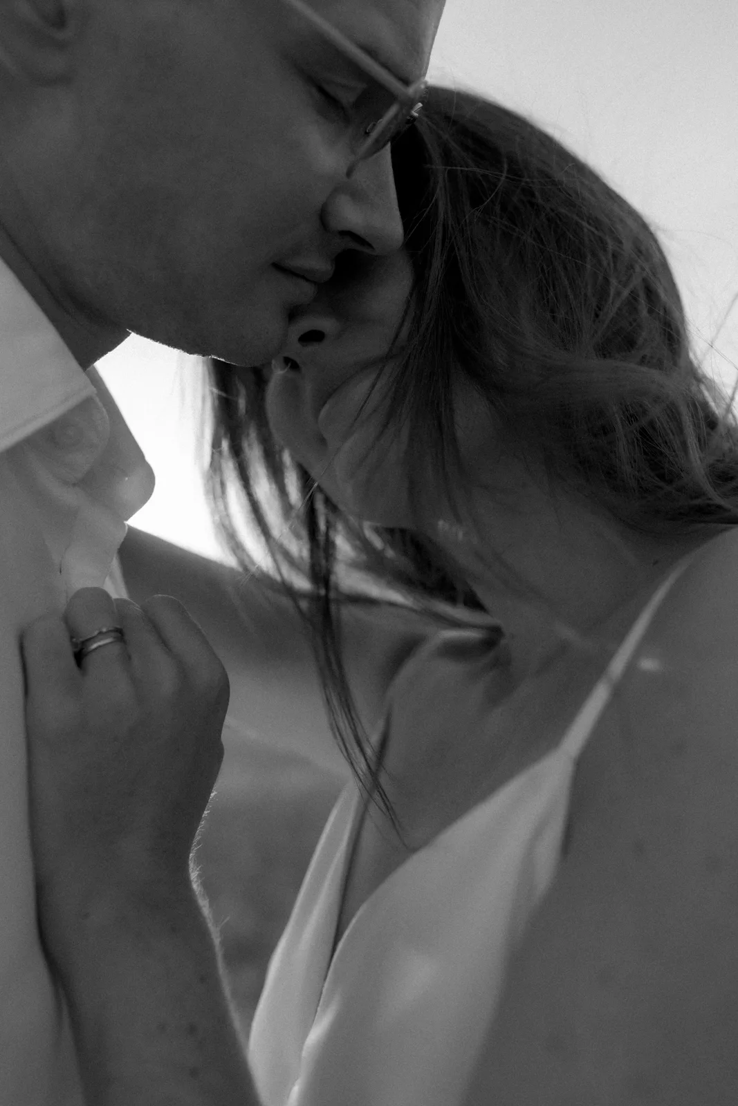 Home 36 A close-up, black-and-white photo of a couple embracing tenderly, their faces close together, with the womans hand resting gently on the mans chest. The mood is intimate and affectionate.